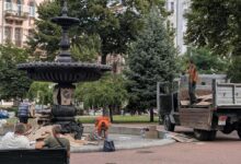 Комунальники прибирають картонні плакати. Фото: The Page