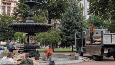 Комунальники прибирають картонні плакати. Фото: The Page